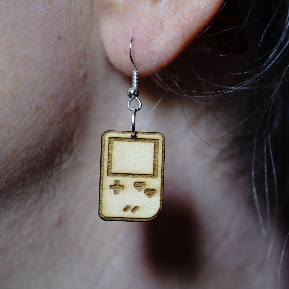 Wooden laser engraved Gameboy earrings with heart-shaped buttons. Lightweight dangle earrings for gamers and retro game lovers. Geeky gift for gamer girls.