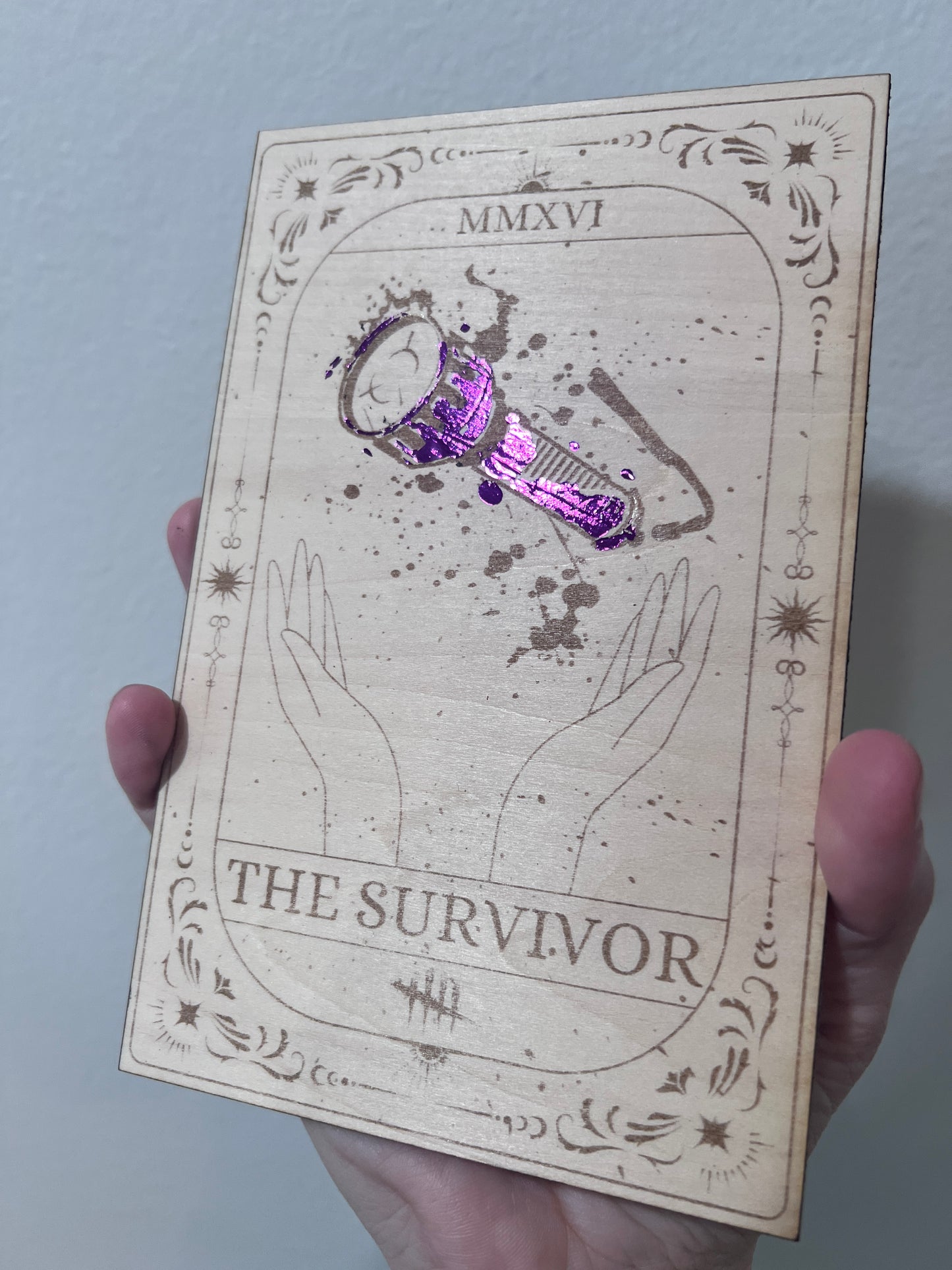 Laser-engraved wooden tarot card inspired by Dead by Daylight, featuring "The Survivor" flashlight design, with purple foiled accents. Horror game decor, perfect for DBD fans and collectors.