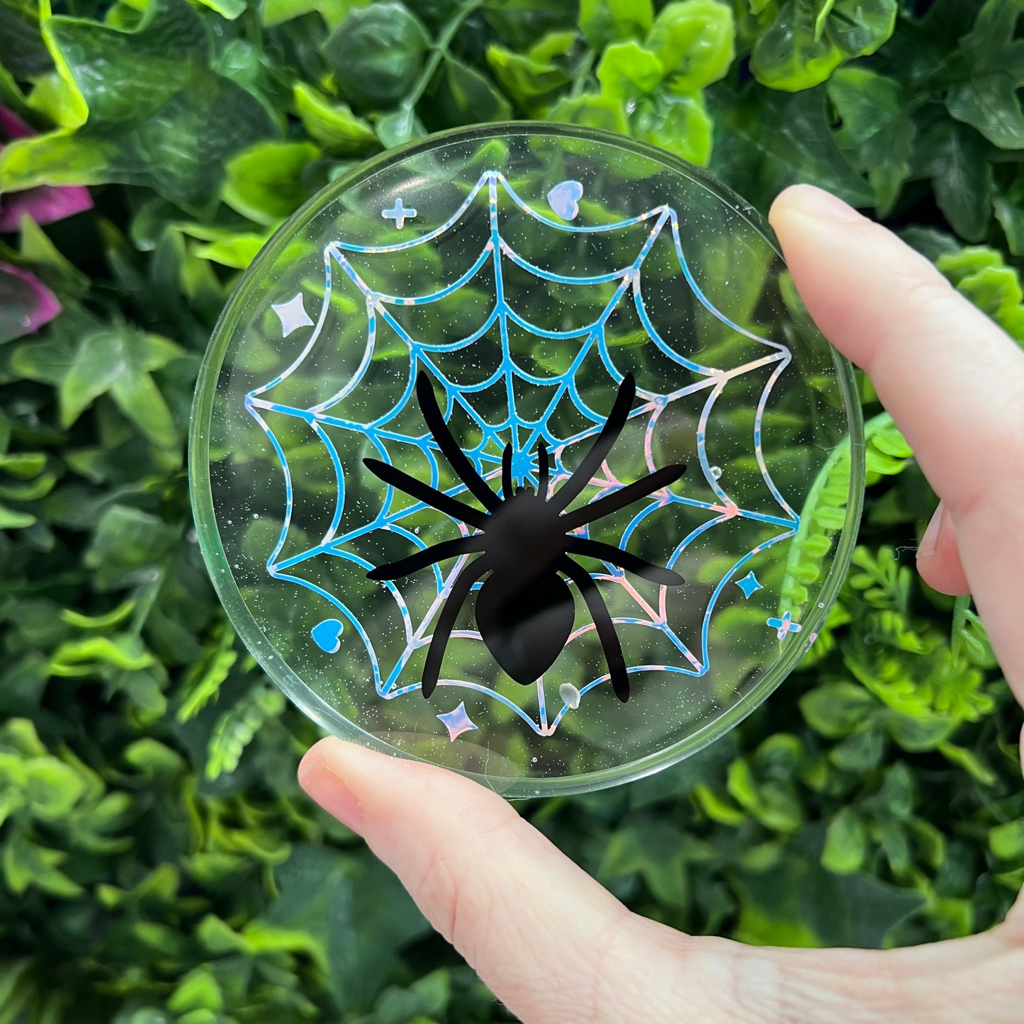Pastel goth spiderweb coasters featuring a handmade resin design with intricate spiderwebs. Perfect for adding a dark, spooky aesthetic to any home. These unique coasters blend pastel colors with a goth twist, great for goth or Halloween-themed decor