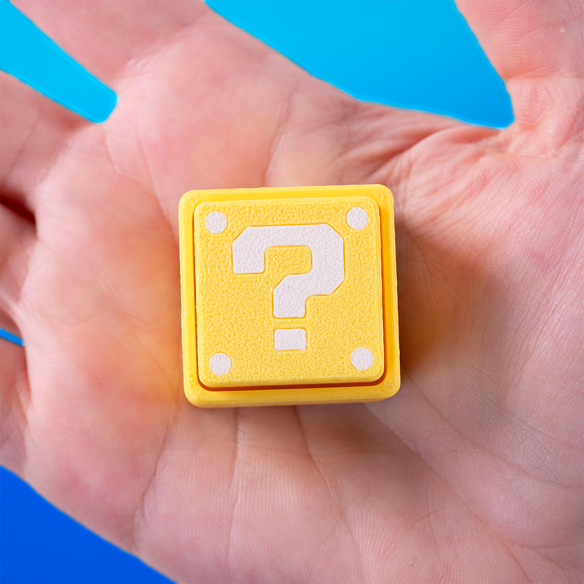 Super Mario-inspired question block fidget clicker, perfect for gamers. Handheld stress relief toy with satisfying click action. Ideal gift for Nintendo fans and retro gaming lovers.