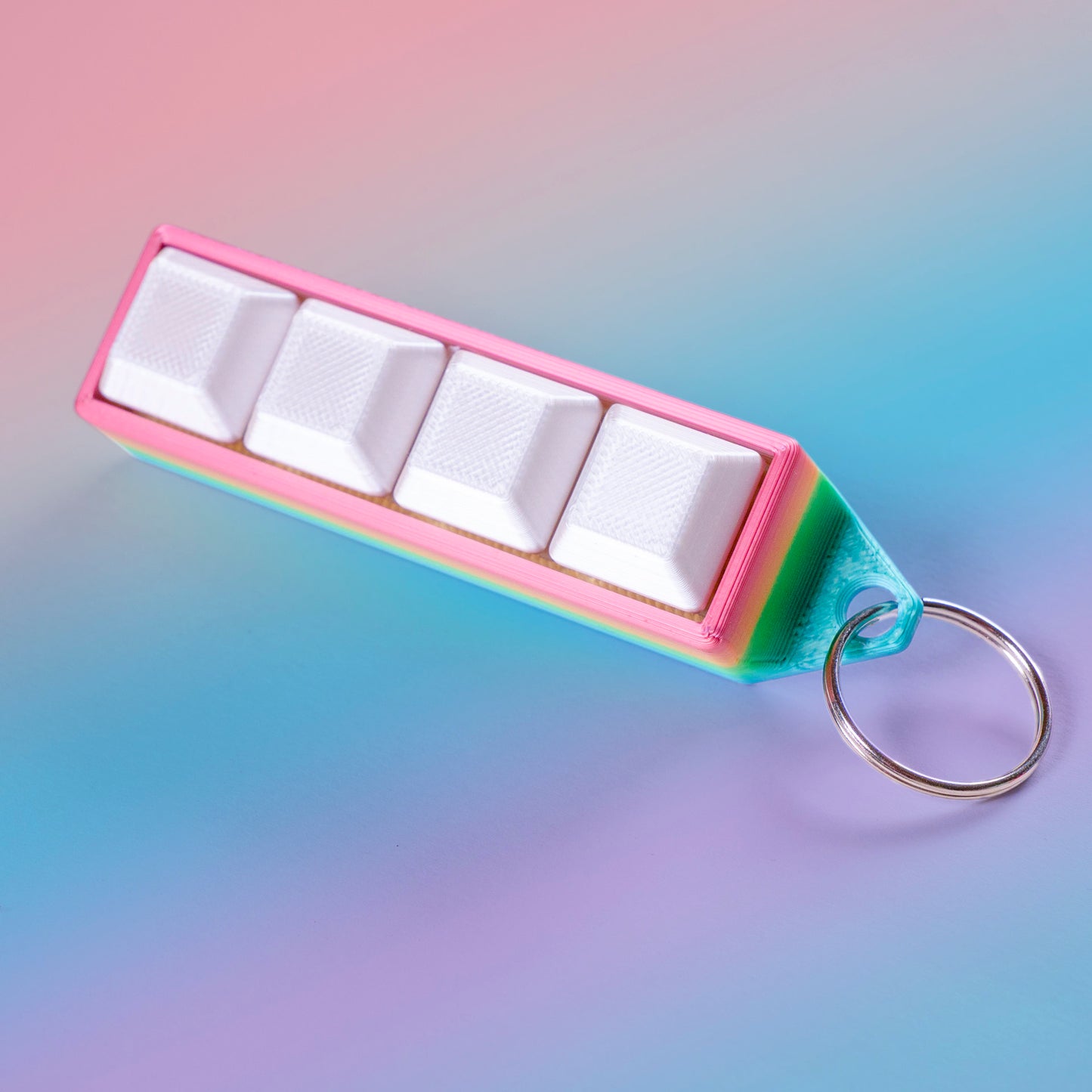Rainbow 4-key mechanical clicker with white keycaps and keychain loop, perfect for fidgeting, gamer desk setups, or stress relief on the go.