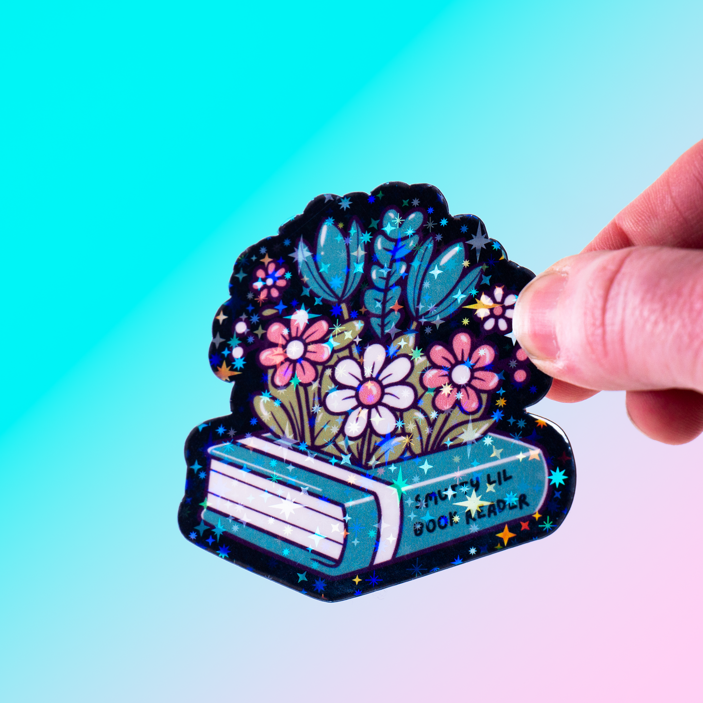 Holographic vinyl sticker featuring flowers growing from a romance book labeled "Smutty Lil Book Reader." Perfect for book lovers, Kindle cases, and bookish decor.