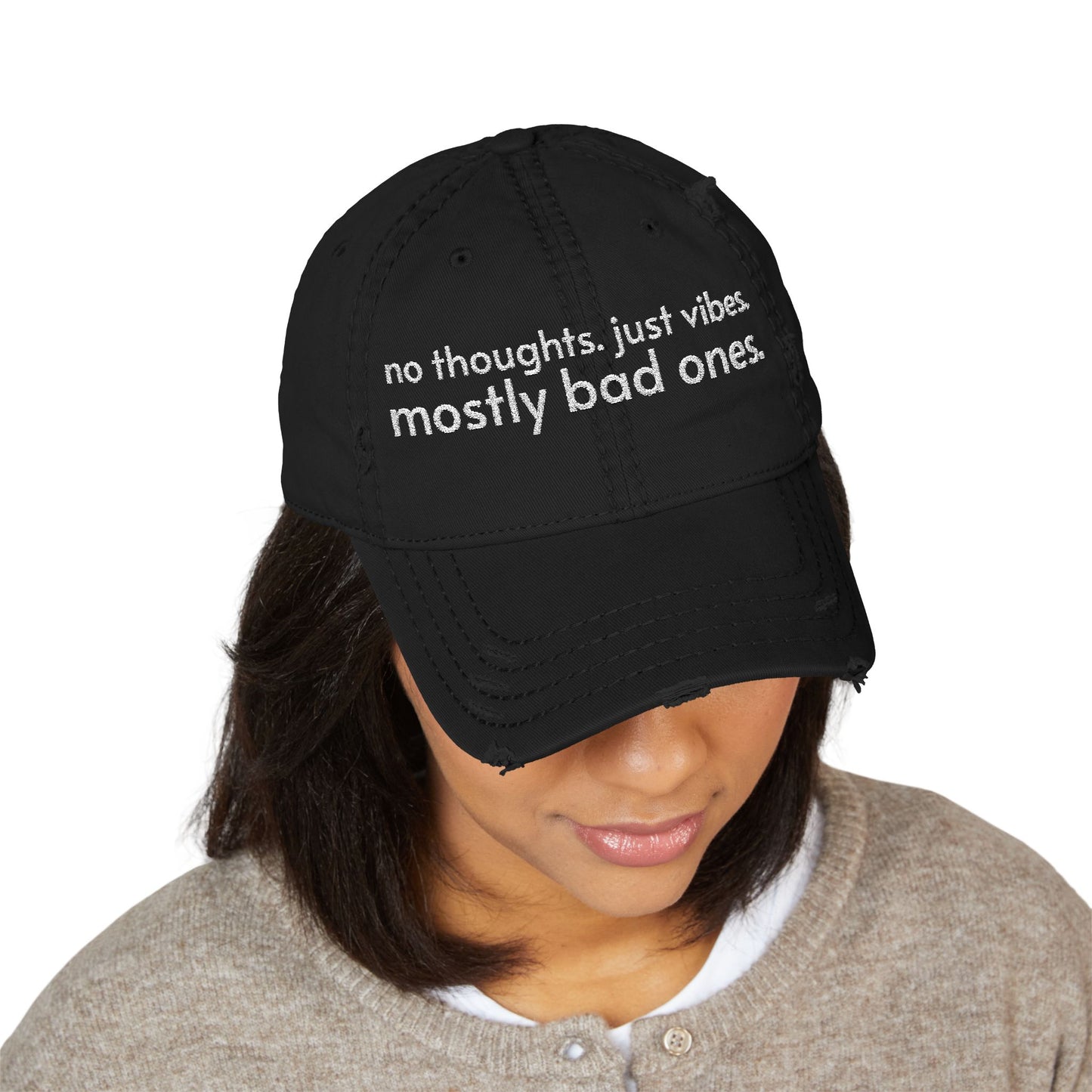 Distressed ball cap embroidered with “no thoughts just vibes mostly bad ones”.