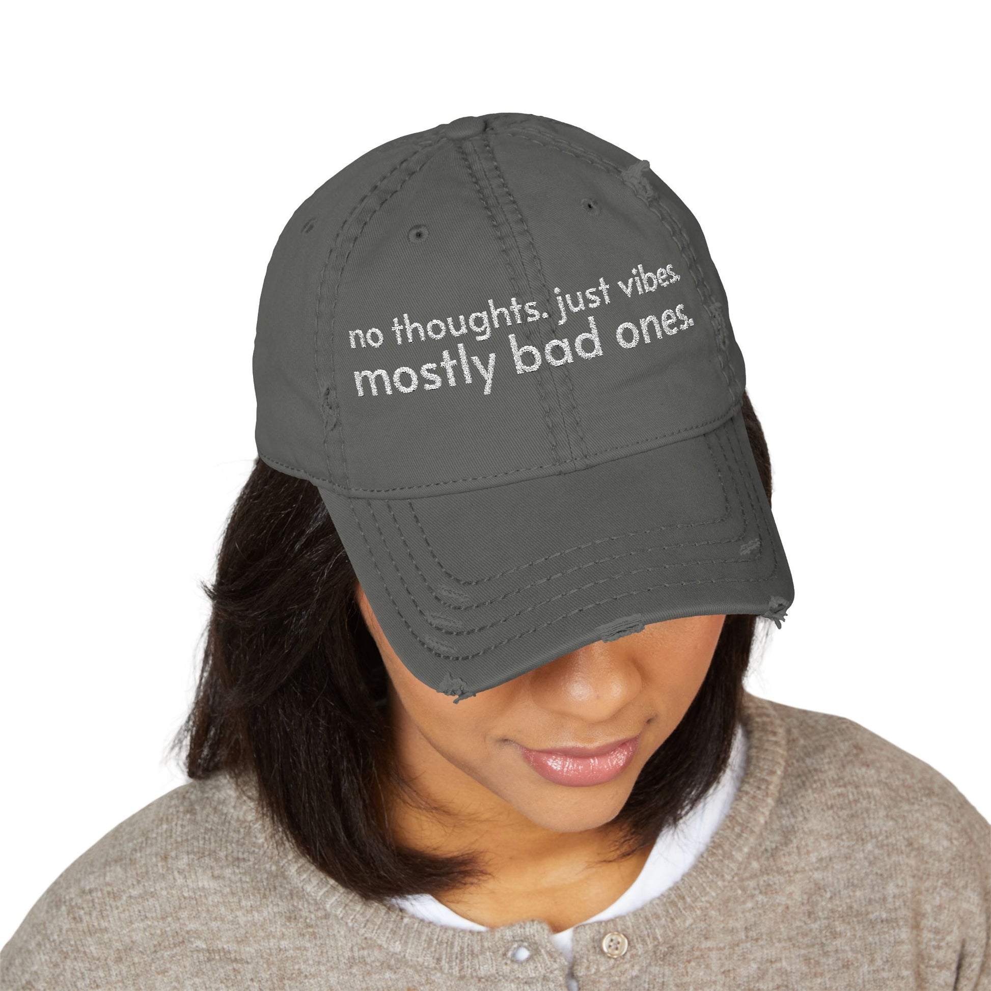 Distressed ball cap embroidered with “no thoughts just vibes mostly bad ones”.