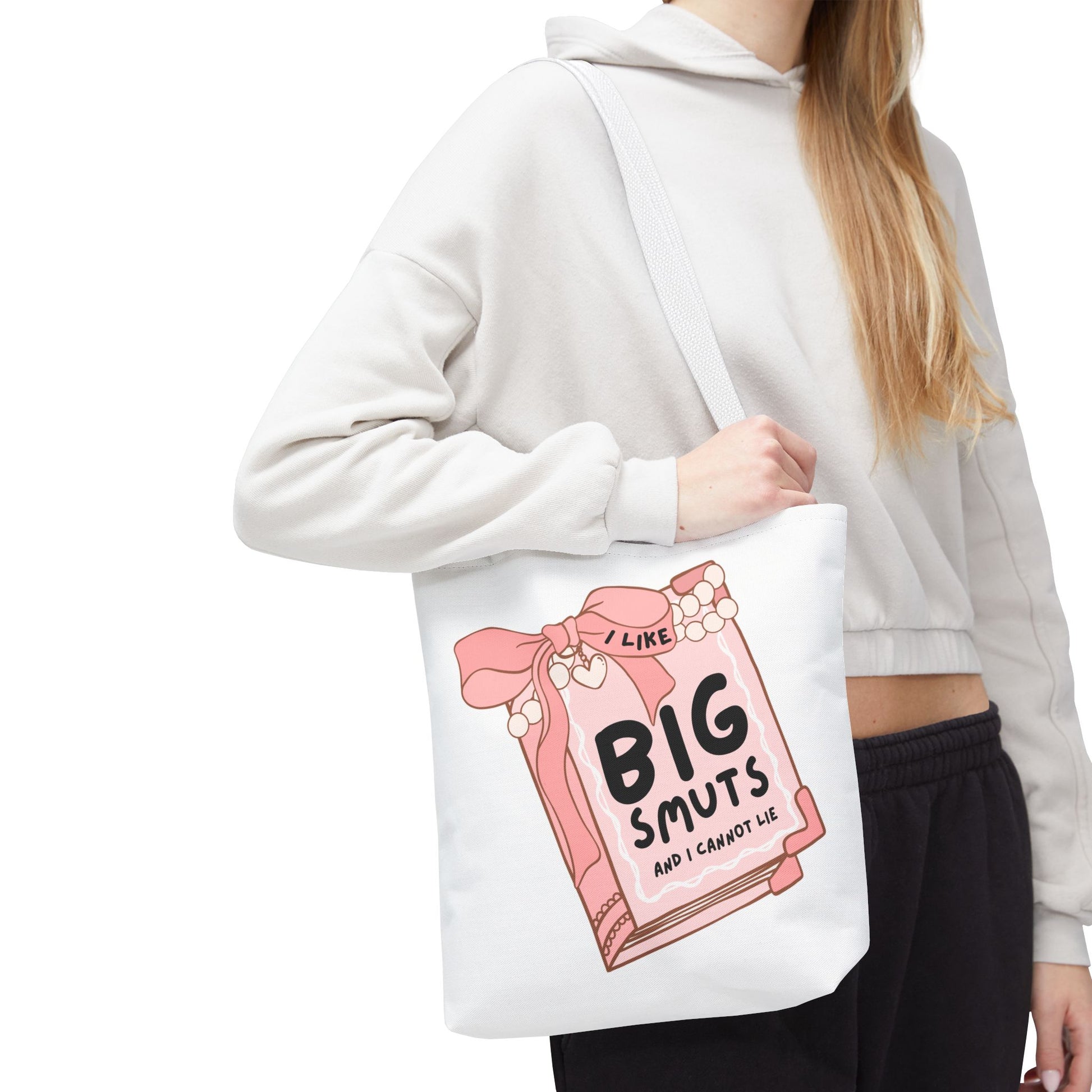 White tote bag with a pink book illustration and the phrase "I Like Big Smuts and I Cannot Lie." Perfect for romance readers, book lovers, and smut enthusiasts.