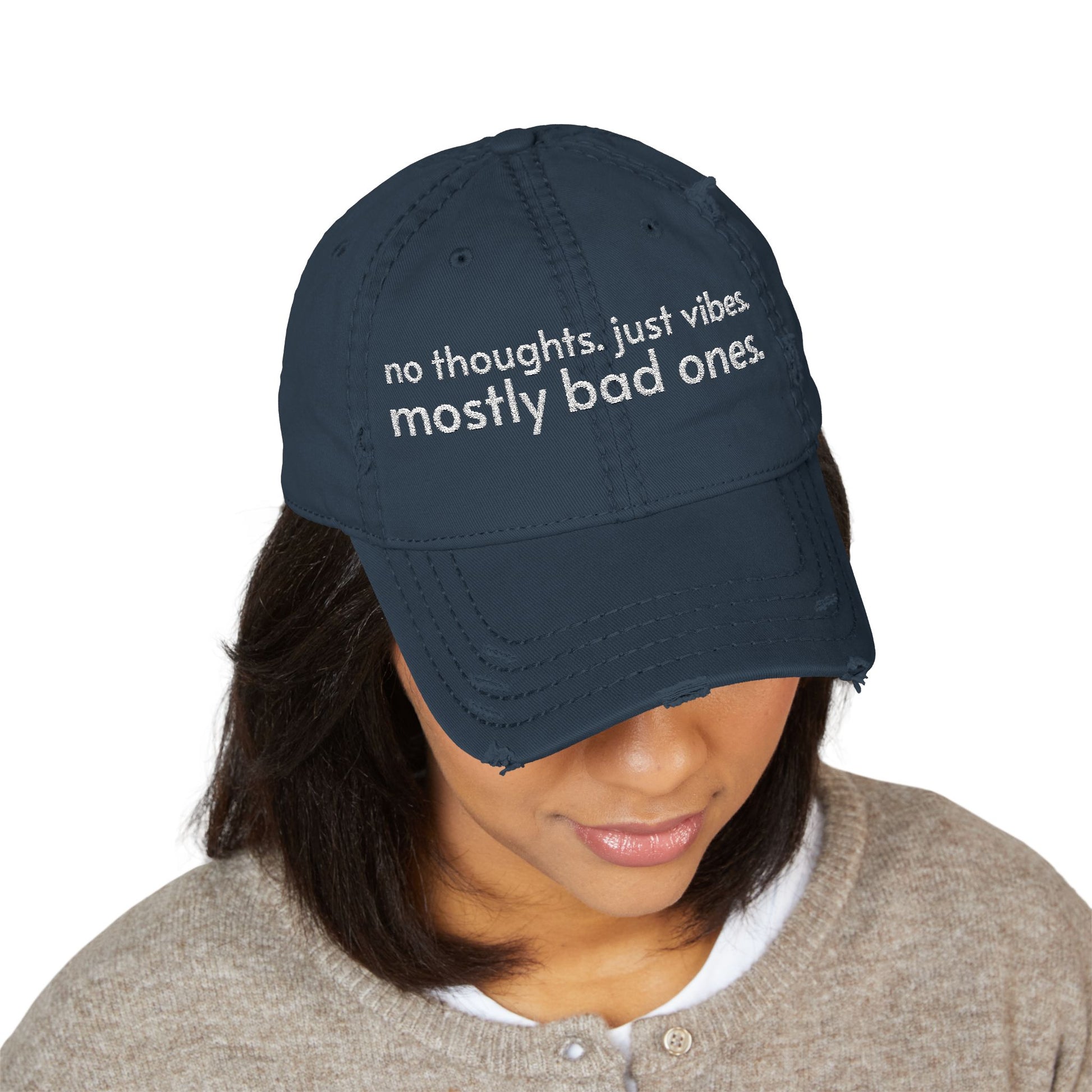 Distressed ball cap embroidered with “no thoughts just vibes mostly bad ones”.