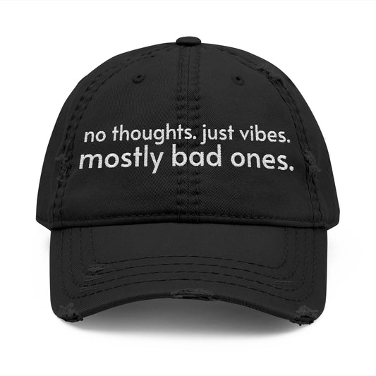 Distressed ball cap embroidered with “no thoughts just vibes mostly bad ones”.