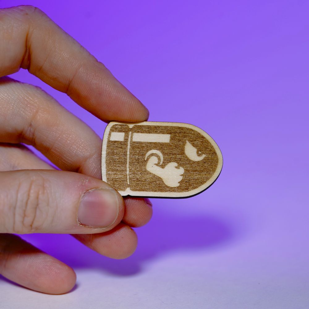 A laser engraved wood pin featuring a stylized Bullet Bill design. Lightweight and handmade, perfect for gamers, pin collectors, and geeky fashion fans.