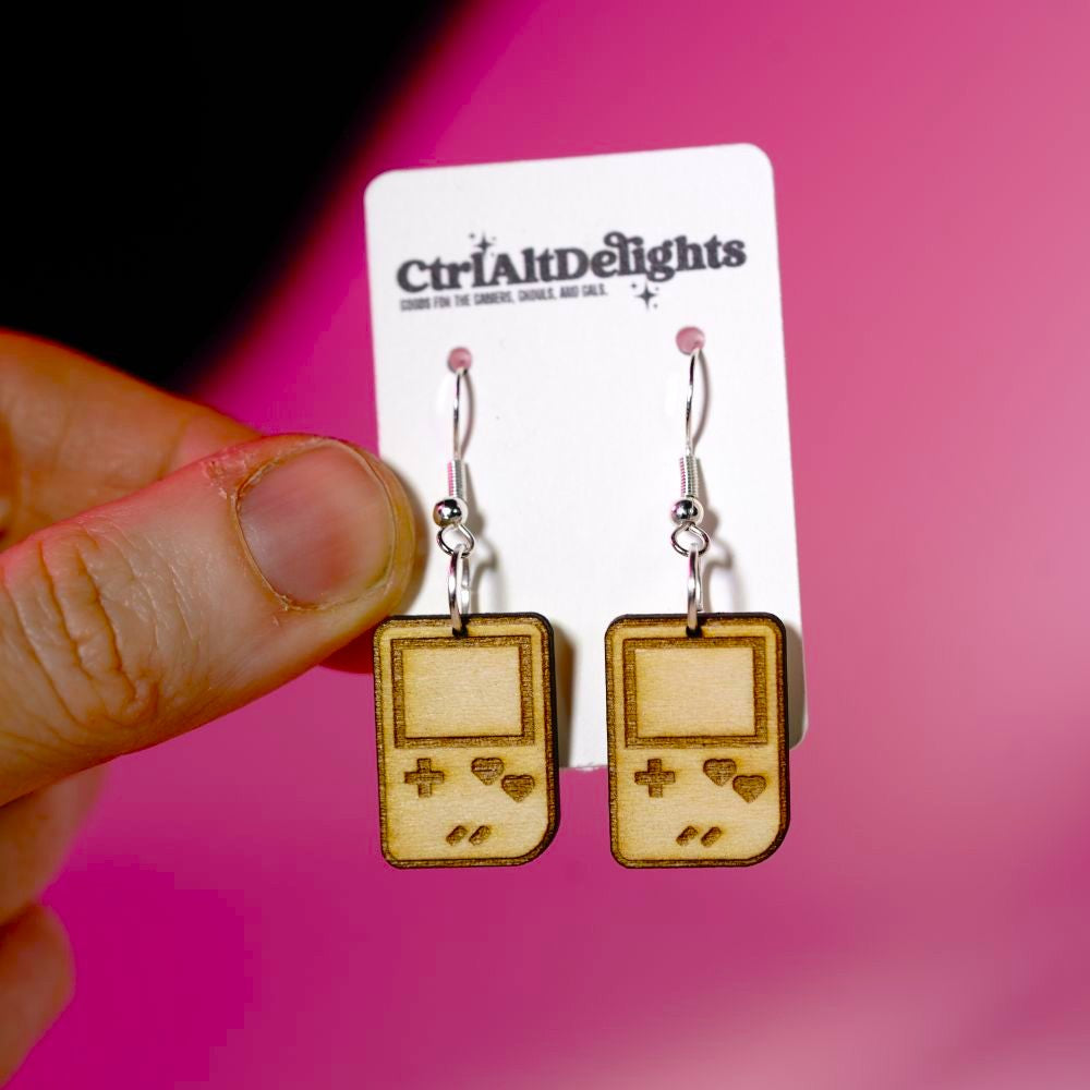 Wooden laser engraved Gameboy earrings with heart-shaped buttons. Lightweight dangle earrings for gamers and retro game lovers. Geeky gift for gamer girls.