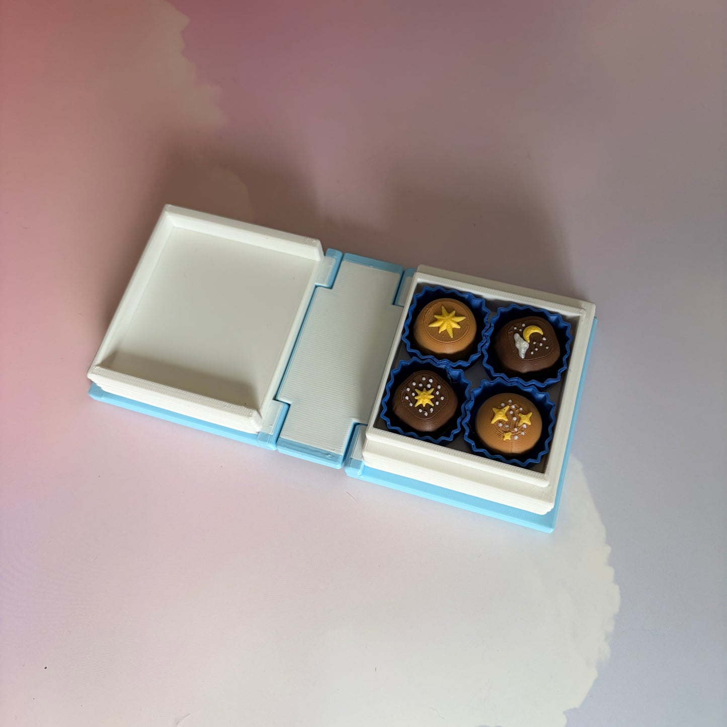 Book-shaped fidget clicker opening to a box of chocolates