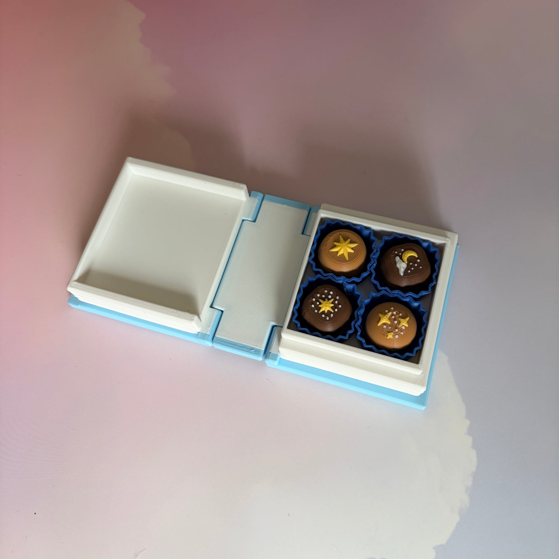 Book-shaped fidget clicker opening to a box of chocolates
