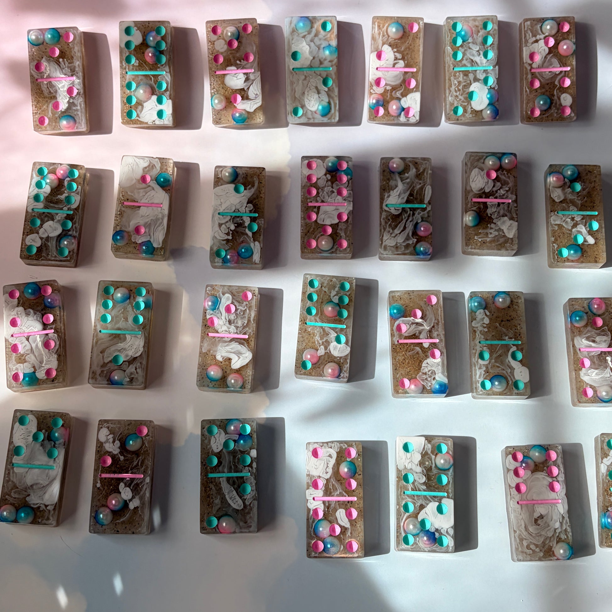 Handmade seashore resin dominoes with pearls and sand.