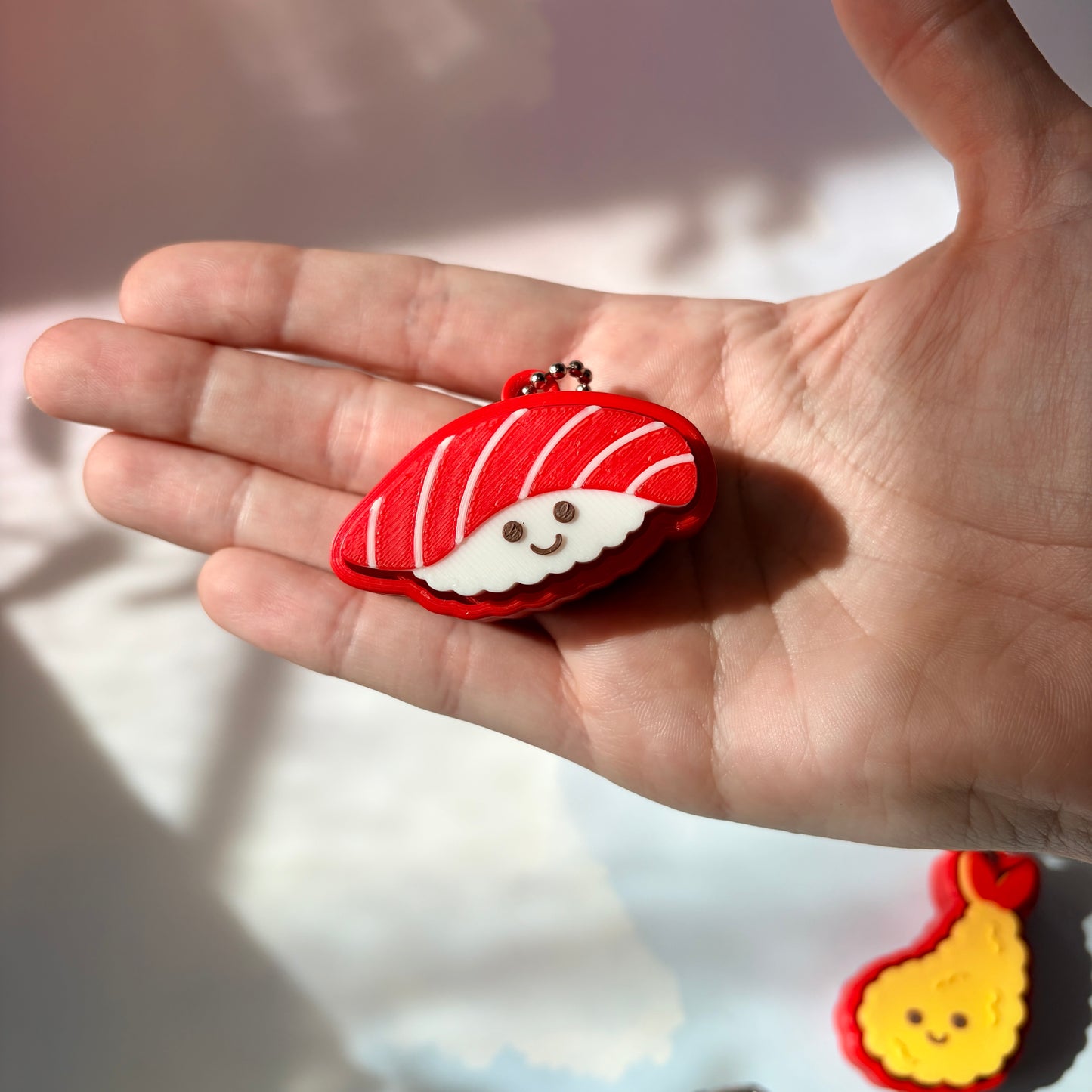 Sushi shaped 3D printed fidget clicker keychain. 