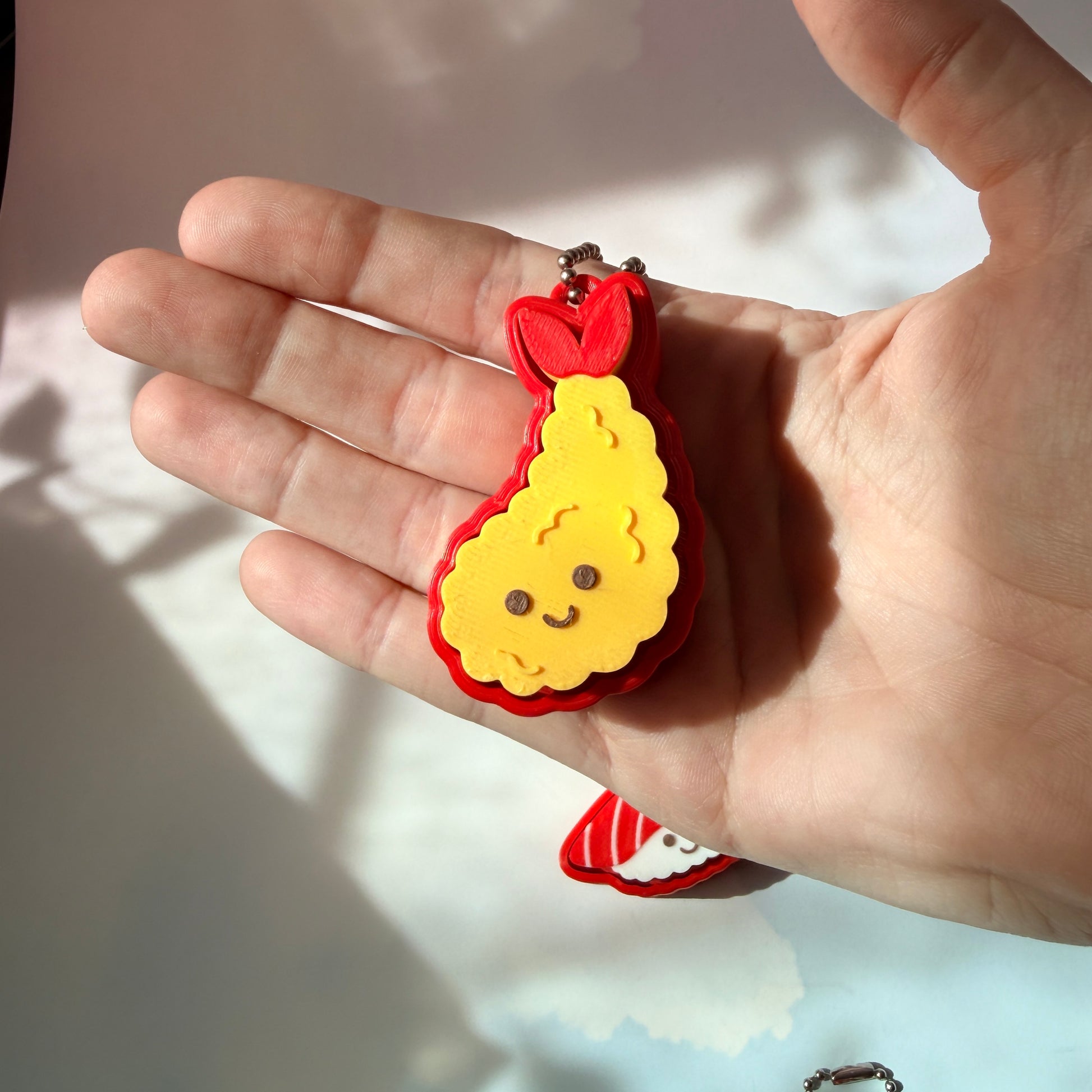 Sushi shaped 3D printed fidget clicker keychain. 