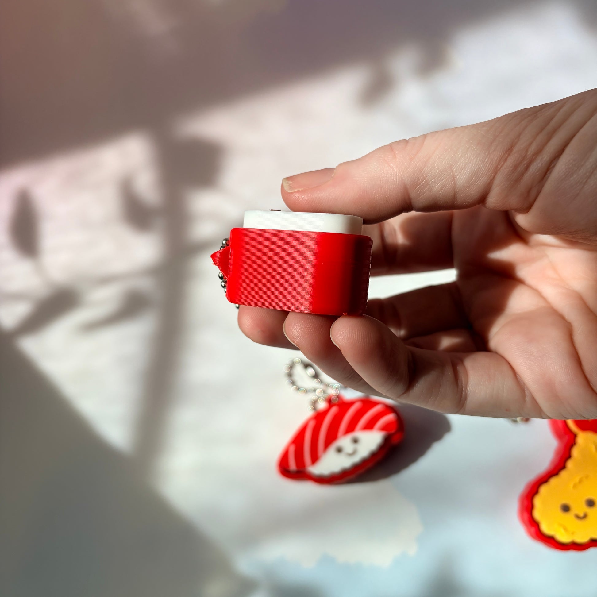Sushi shaped 3D printed fidget clicker keychain. 