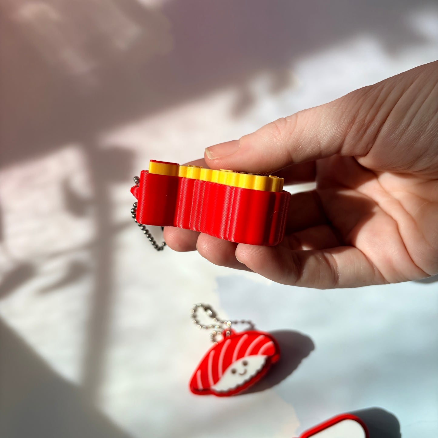 Sushi shaped 3D printed fidget clicker keychain. 