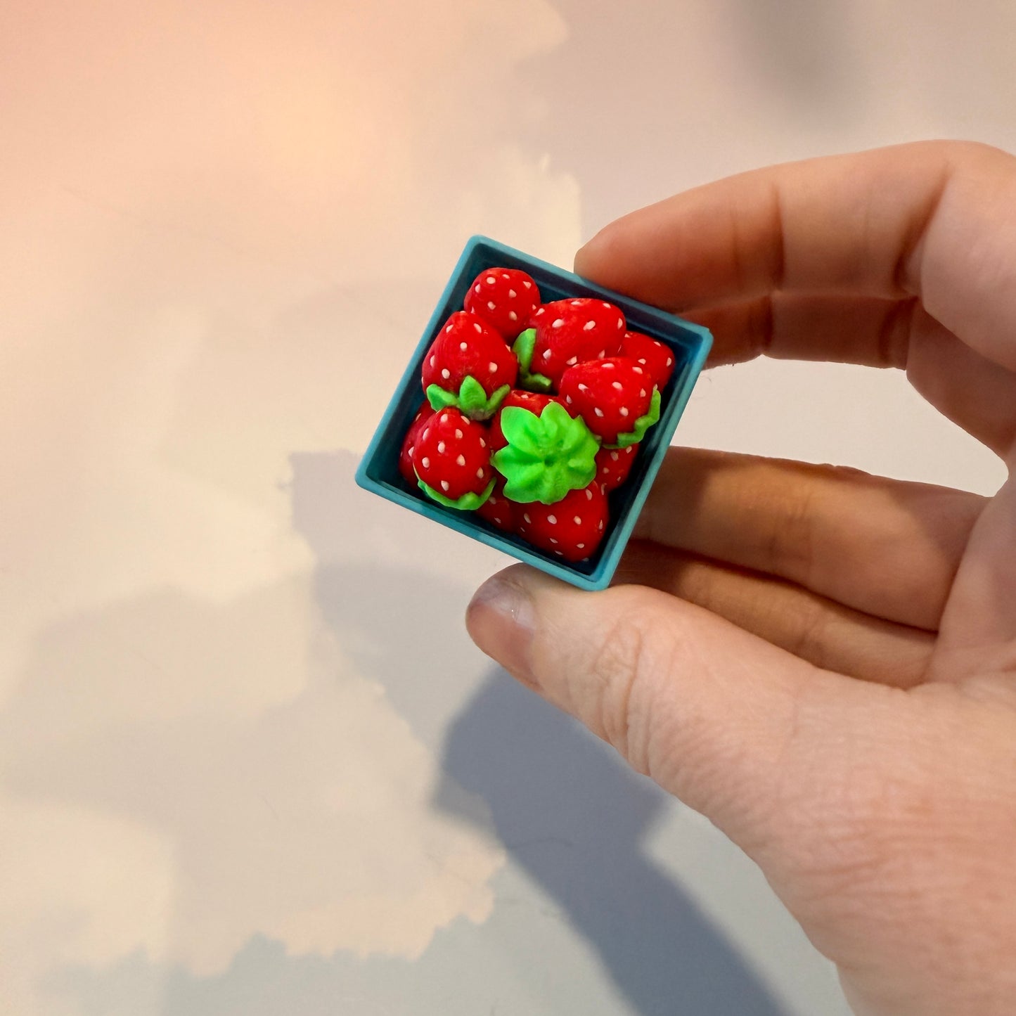 Farmers market themed fidget clicker featuring strawberries and frogs.