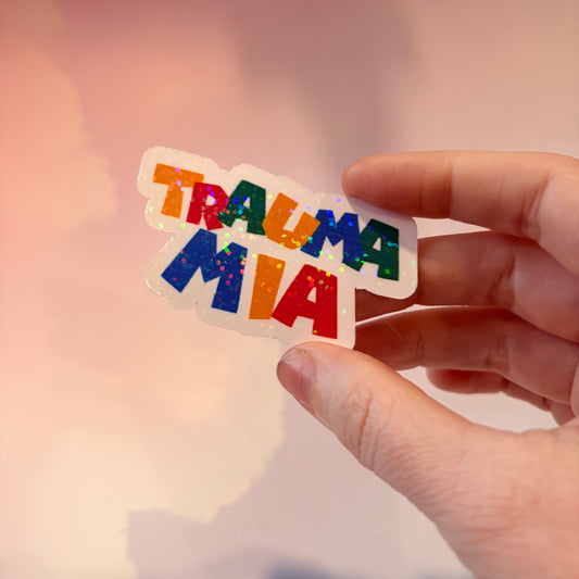 Holographic Trauma Mia sticker in retro video game style lettering.