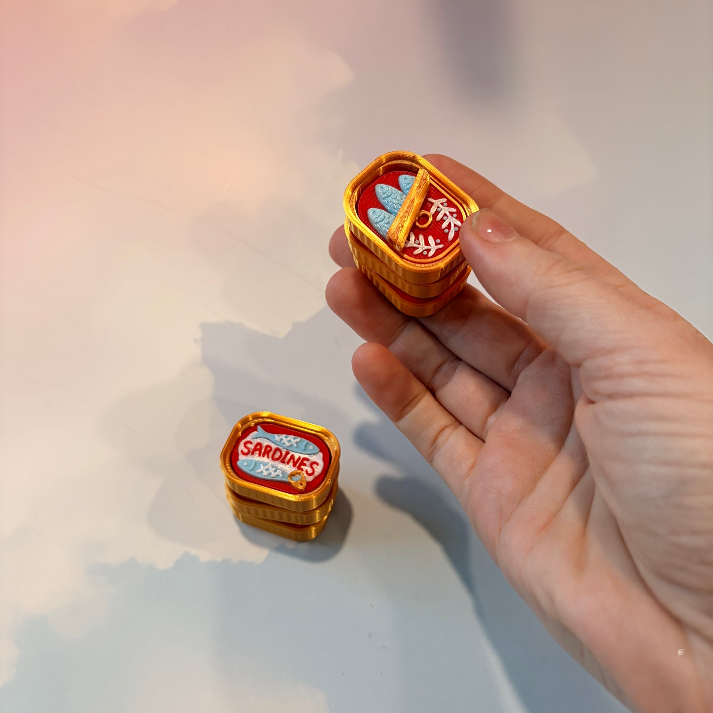 Sardine tin fidget clicker inspired by tinned fish packaging.