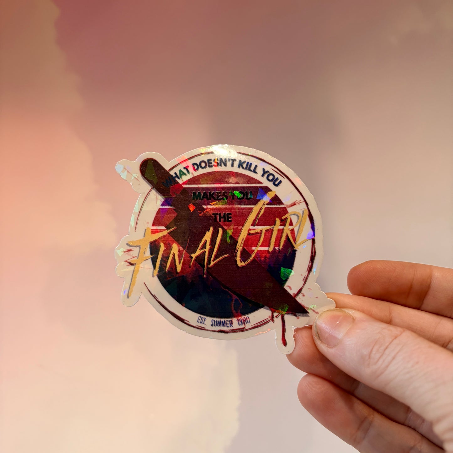 Sticker with text 'What doesn't kill you makes you the final girl' and a knife on a white background