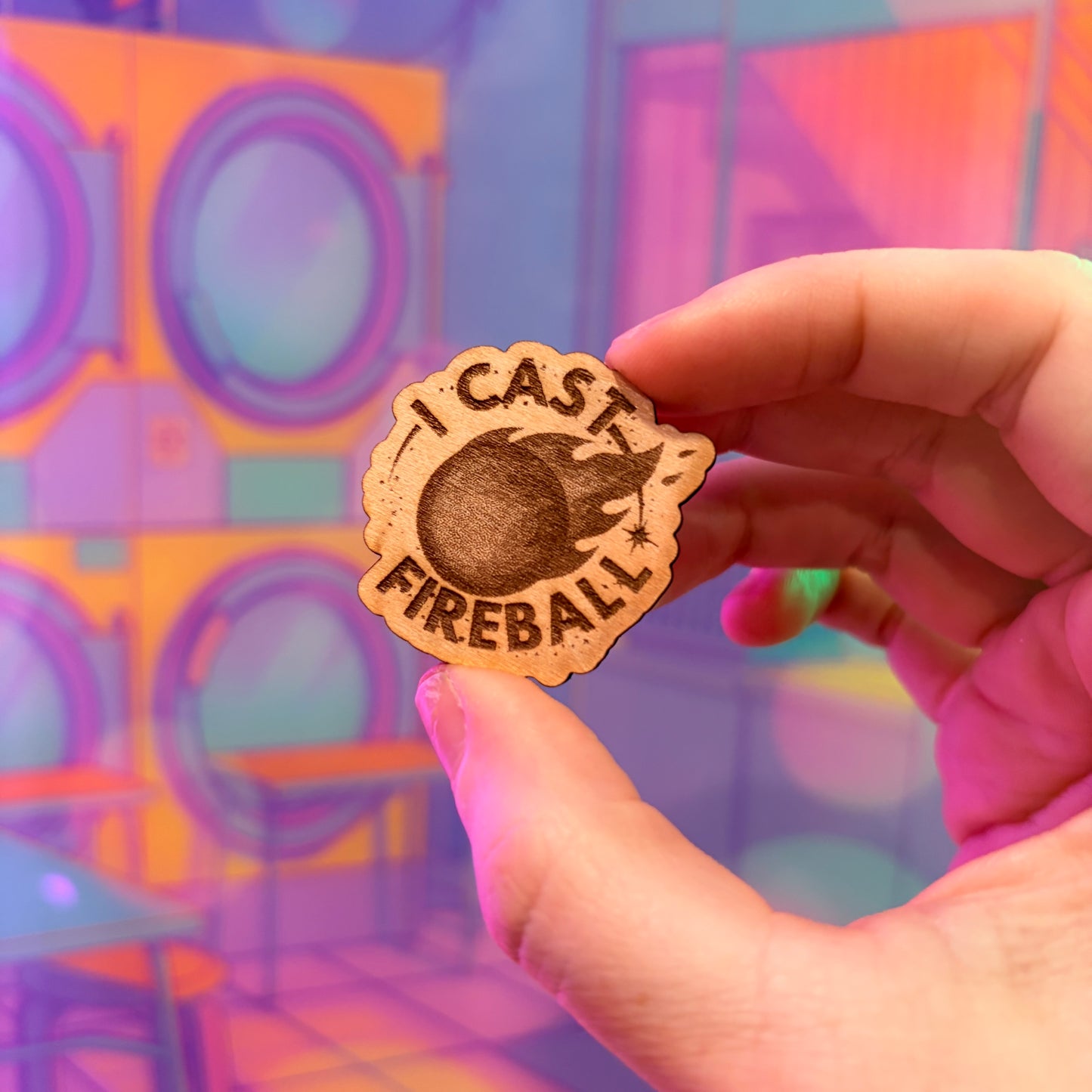 Laser engraved basswood pin reading "I Cast Fireball" for tabletop gamers.