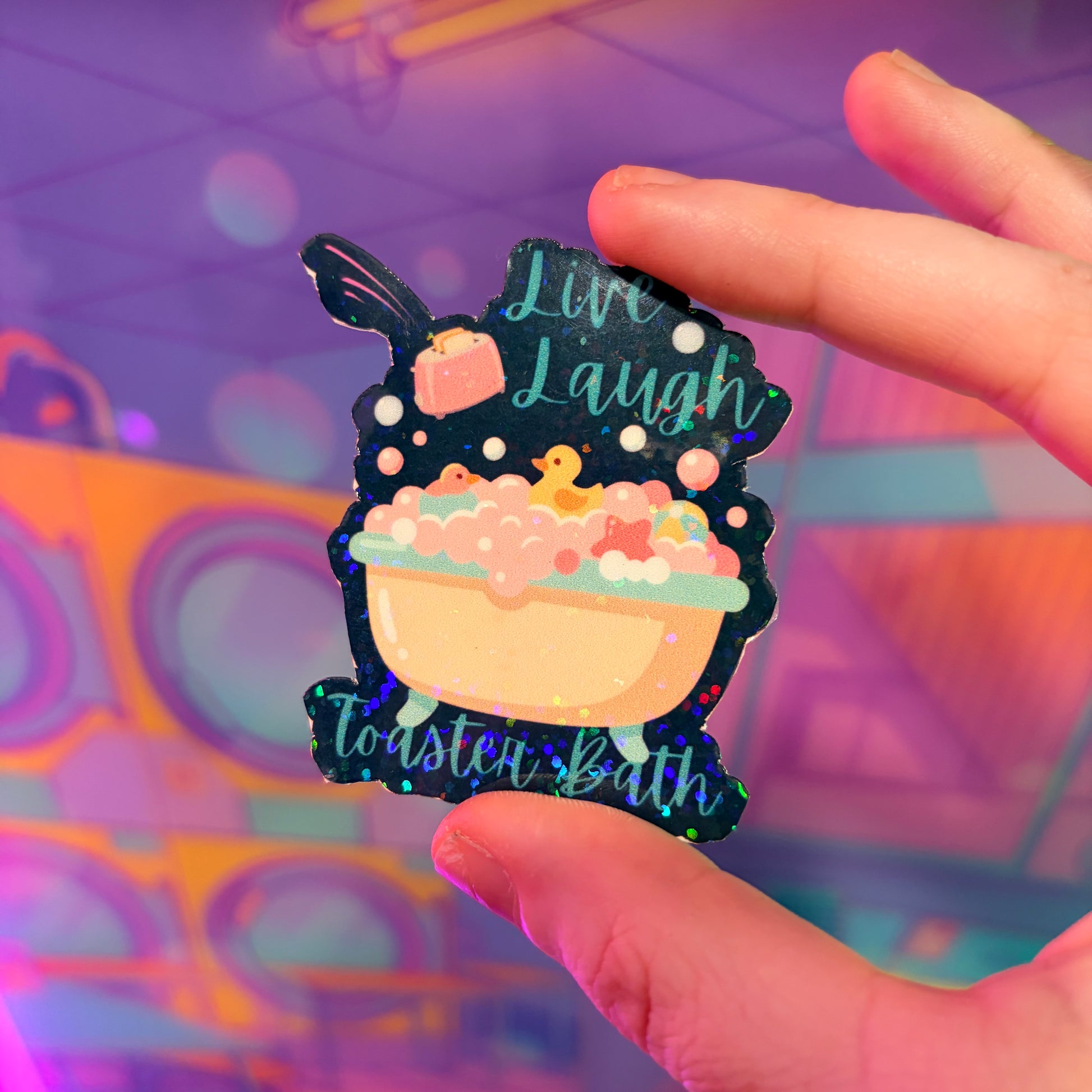 Holographic Live Laugh Toaster Bath vinyl sticker with bathtub, bubbles, rubber duck, and flying toaster.