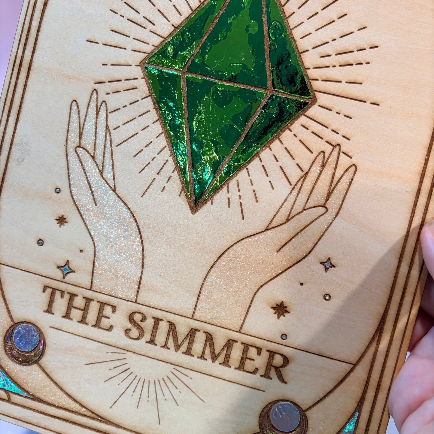 Large laser engraved wooden tarot card featuring a colorful Sims-inspired plumbob with holographic gold and silver foil accents.