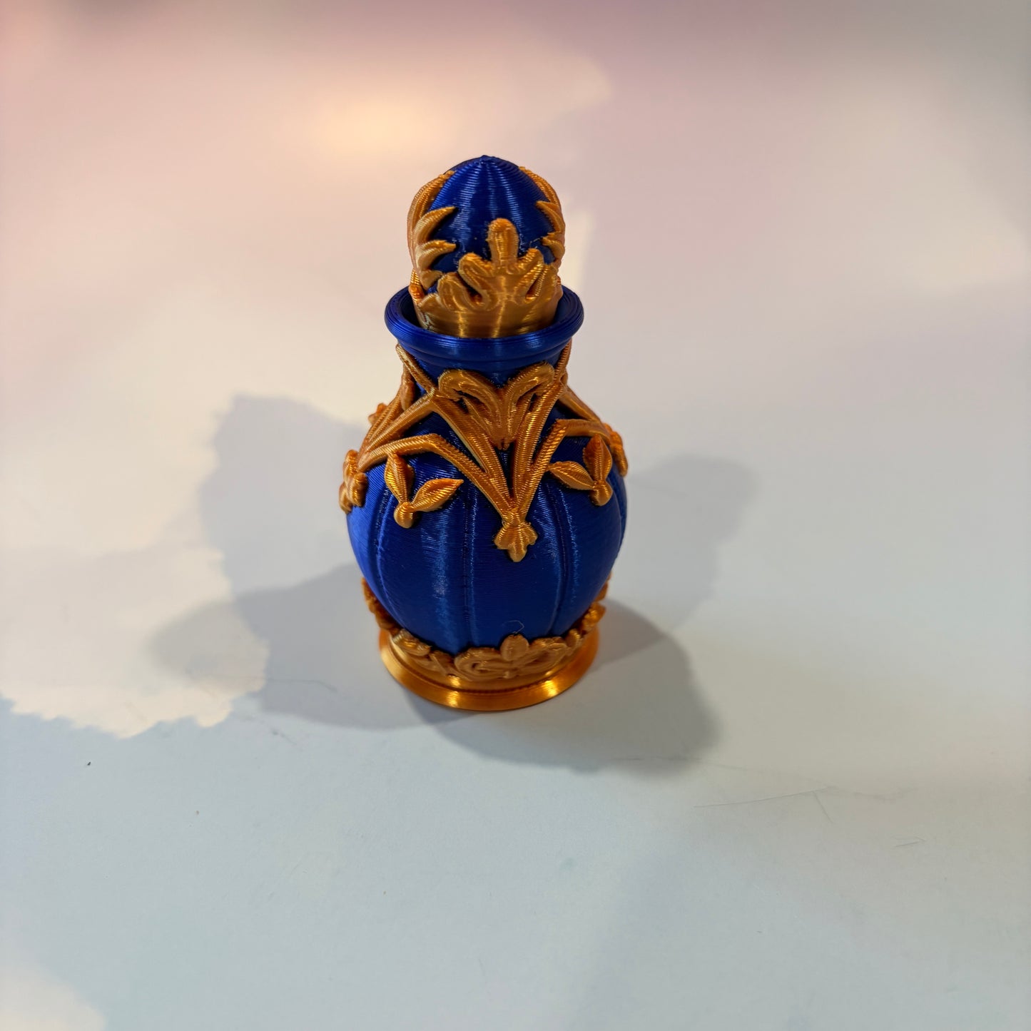 Royal blue and gold 3D printed potion bottle fidget clicker with ornate fantasy details, available in clicky or silent versions.