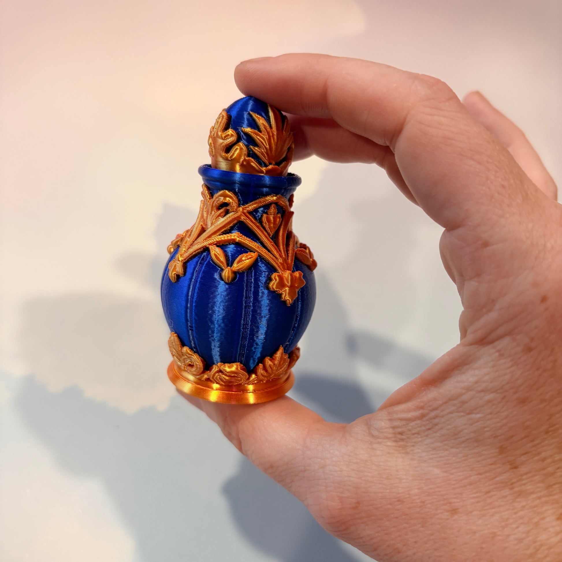 Royal blue and gold 3D printed potion bottle fidget clicker with ornate fantasy details, available in clicky or silent versions.