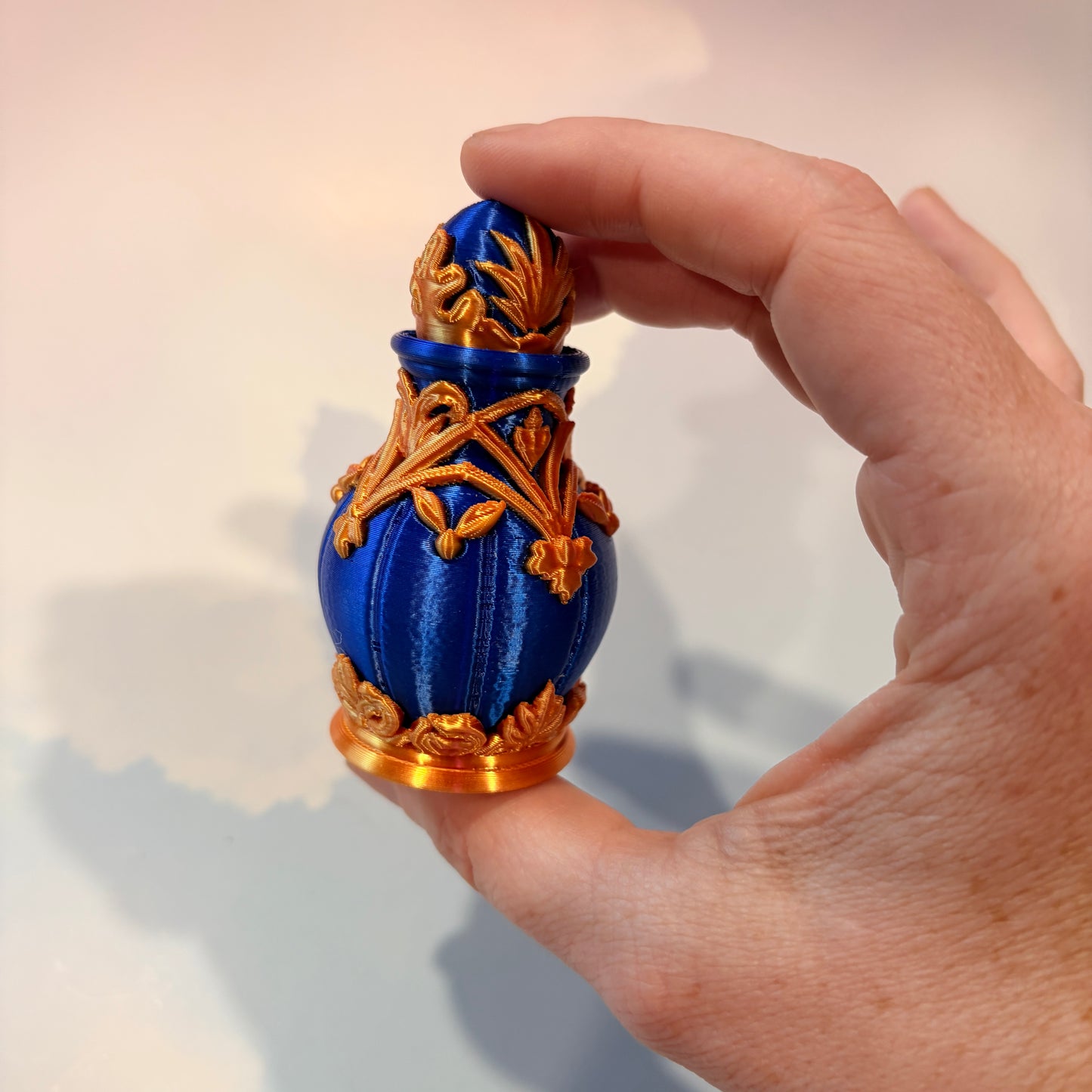 Royal blue and gold 3D printed potion bottle fidget clicker with ornate fantasy details, available in clicky or silent versions.