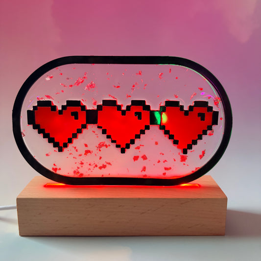Handmade LED pixel heart container light with a hand-poured resin panel, silver leaf accents, laser-cut acrylic hearts, and customizable RGB lighting.
