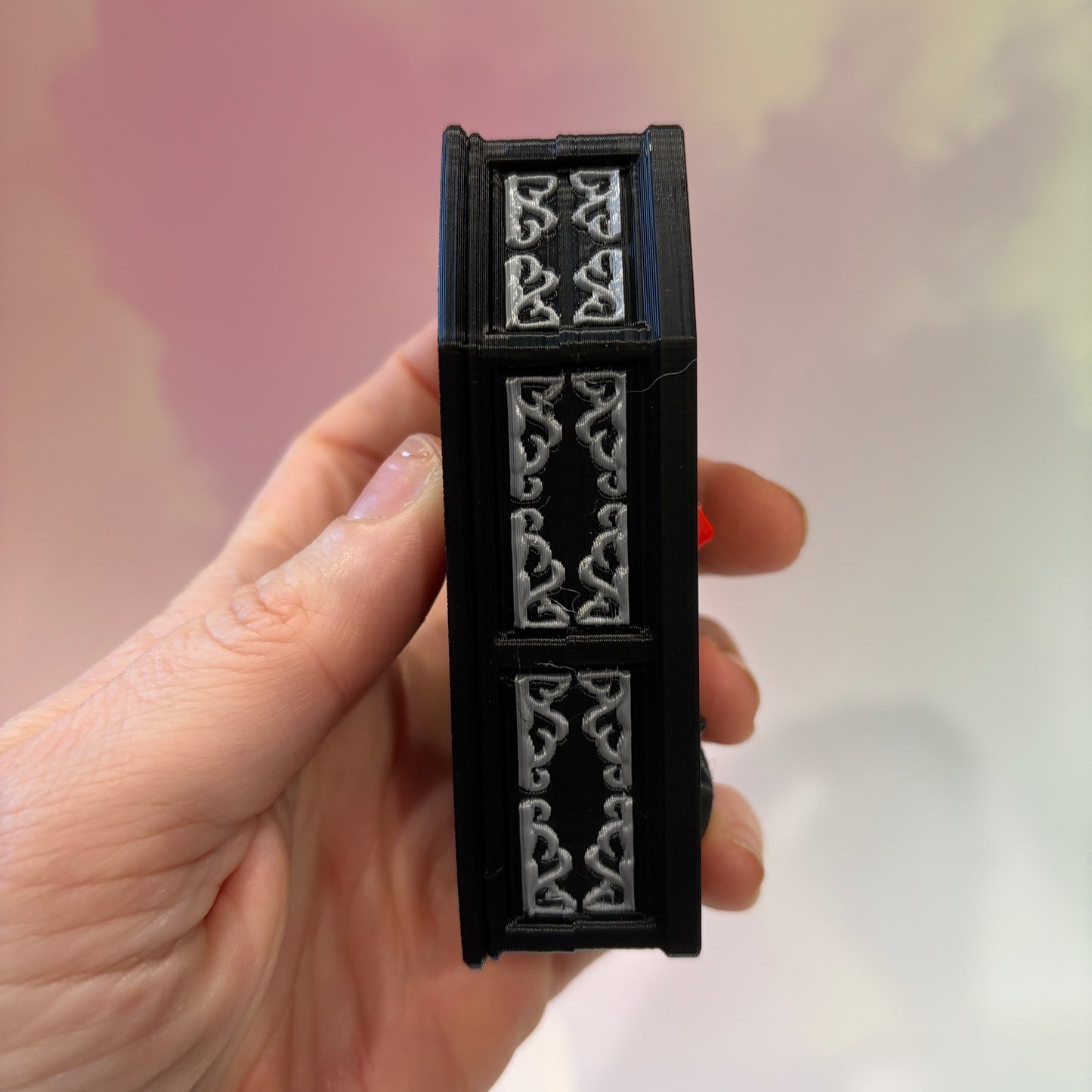 Mini 3D printed black coffin shelf fidget clicker with silver gothic trim and red interior. Features three decorative keycaps: a framed black spider, a ghost reading a book, and a bubbling green cauldron. Includes a silver keychain and is available with clicky or silent switches.