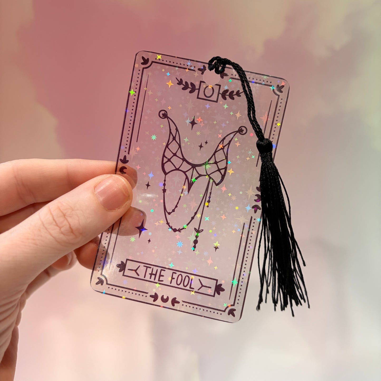 Clear holographic tarot card bookmark with elegant black line art on transparent waterproof cardstock. Finished with a black tassel and shimmering holographic pattern that changes in the light. Available in all 22 Major Arcana designs.