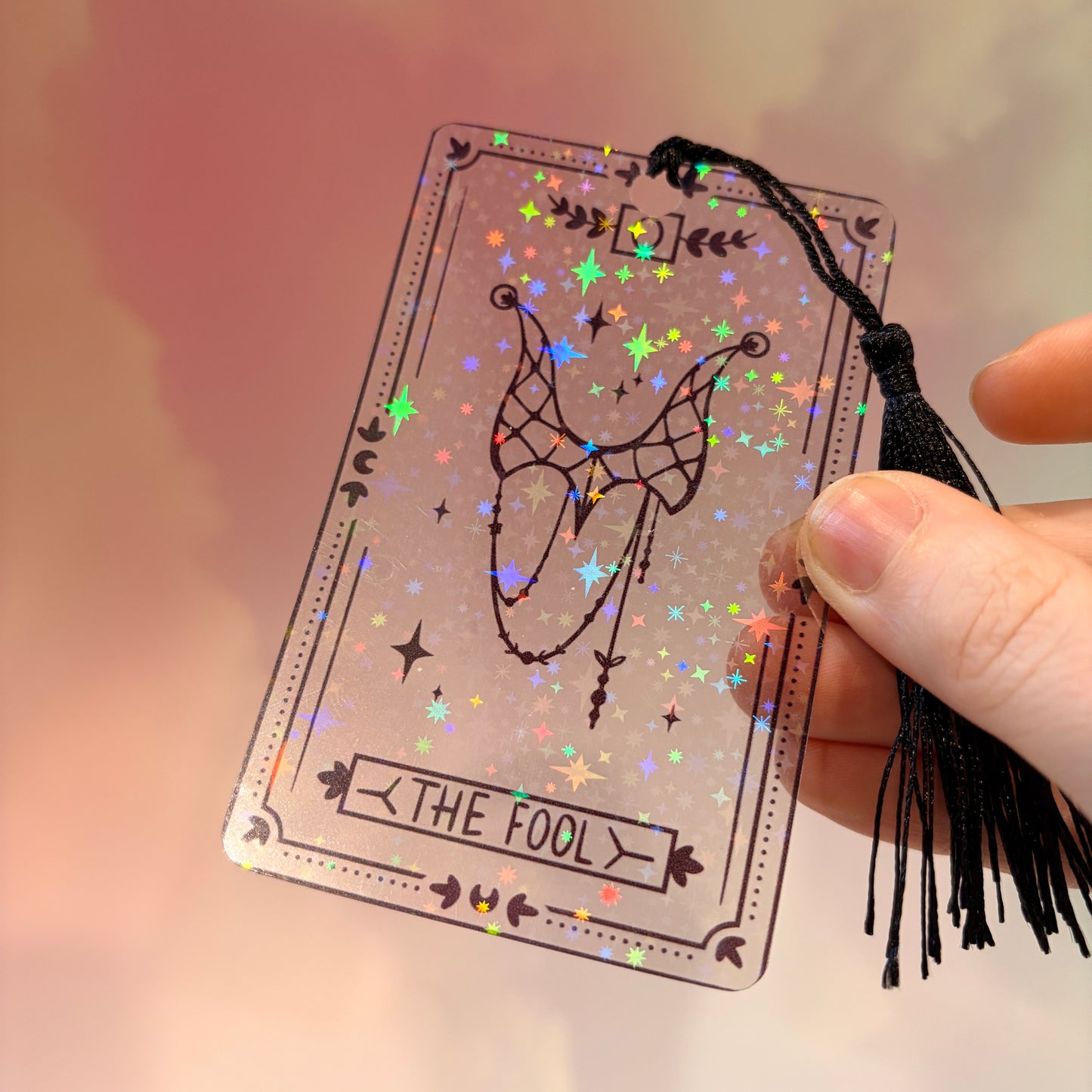 Clear holographic tarot card bookmark with elegant black line art on transparent waterproof cardstock. Finished with a black tassel and shimmering holographic pattern that changes in the light. Available in all 22 Major Arcana designs.