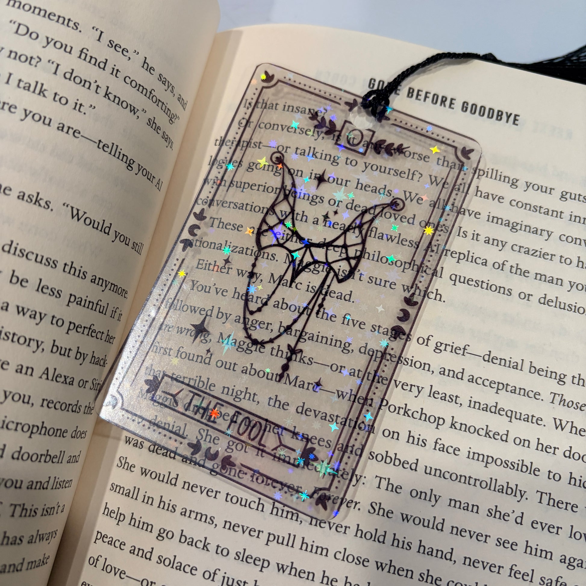 Clear holographic tarot card bookmark with elegant black line art on transparent waterproof cardstock. Finished with a black tassel and shimmering holographic pattern that changes in the light. Available in all 22 Major Arcana designs.
