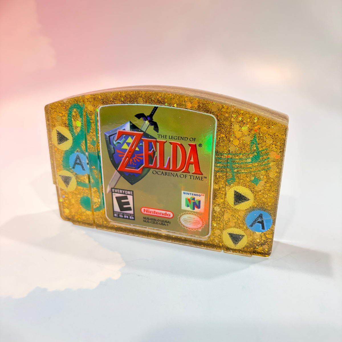 This handmade Zelda Ocarina of Time resin cartridge features vibrant custom art, adding a nostalgic touch for retro gaming fans. Ideal as a unique gift or display piece for collectors and gamers alike. 