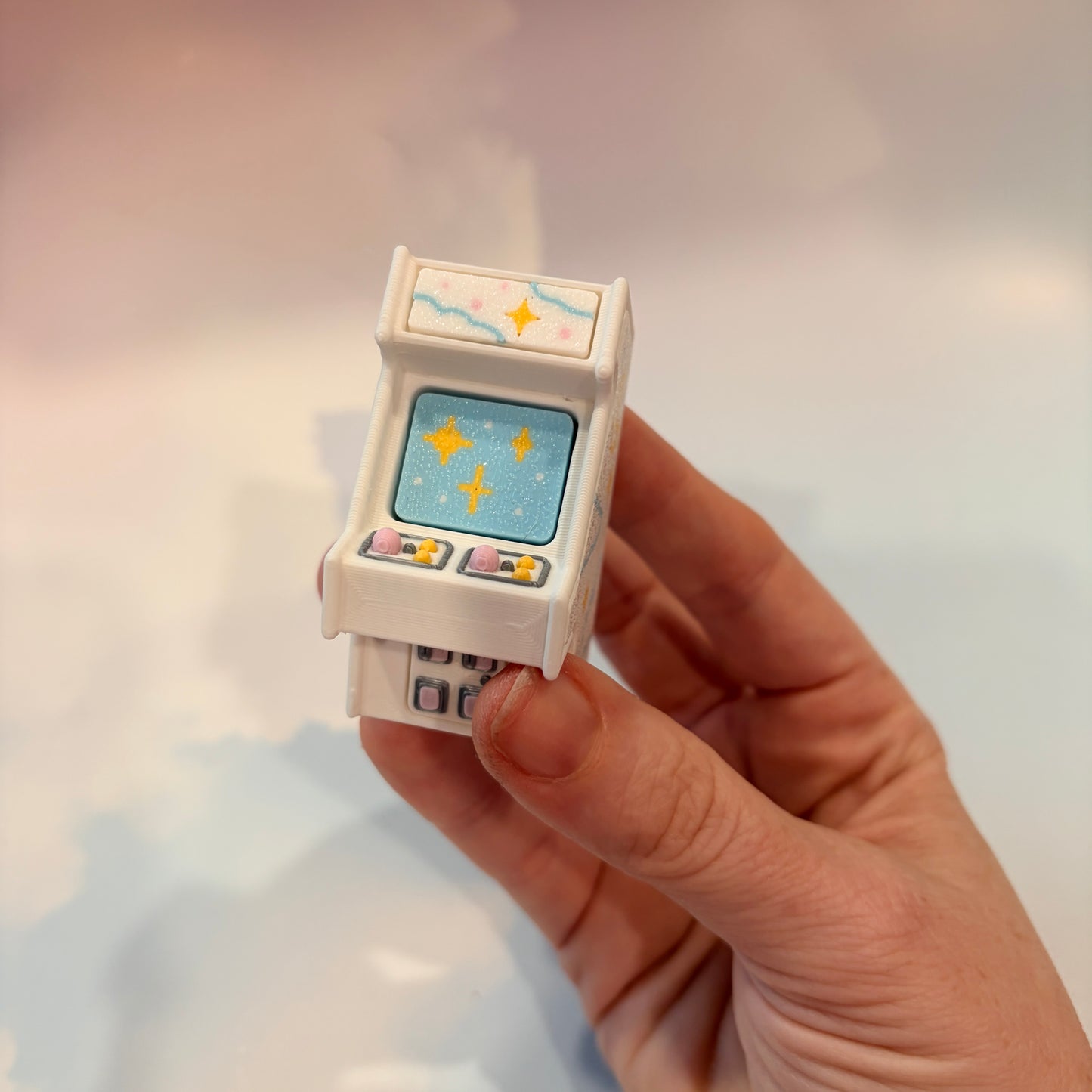Mini retro arcade machine fidget clicker keychain with pastel color way, blue screen, and 3D printed design, available in clicky or silent.