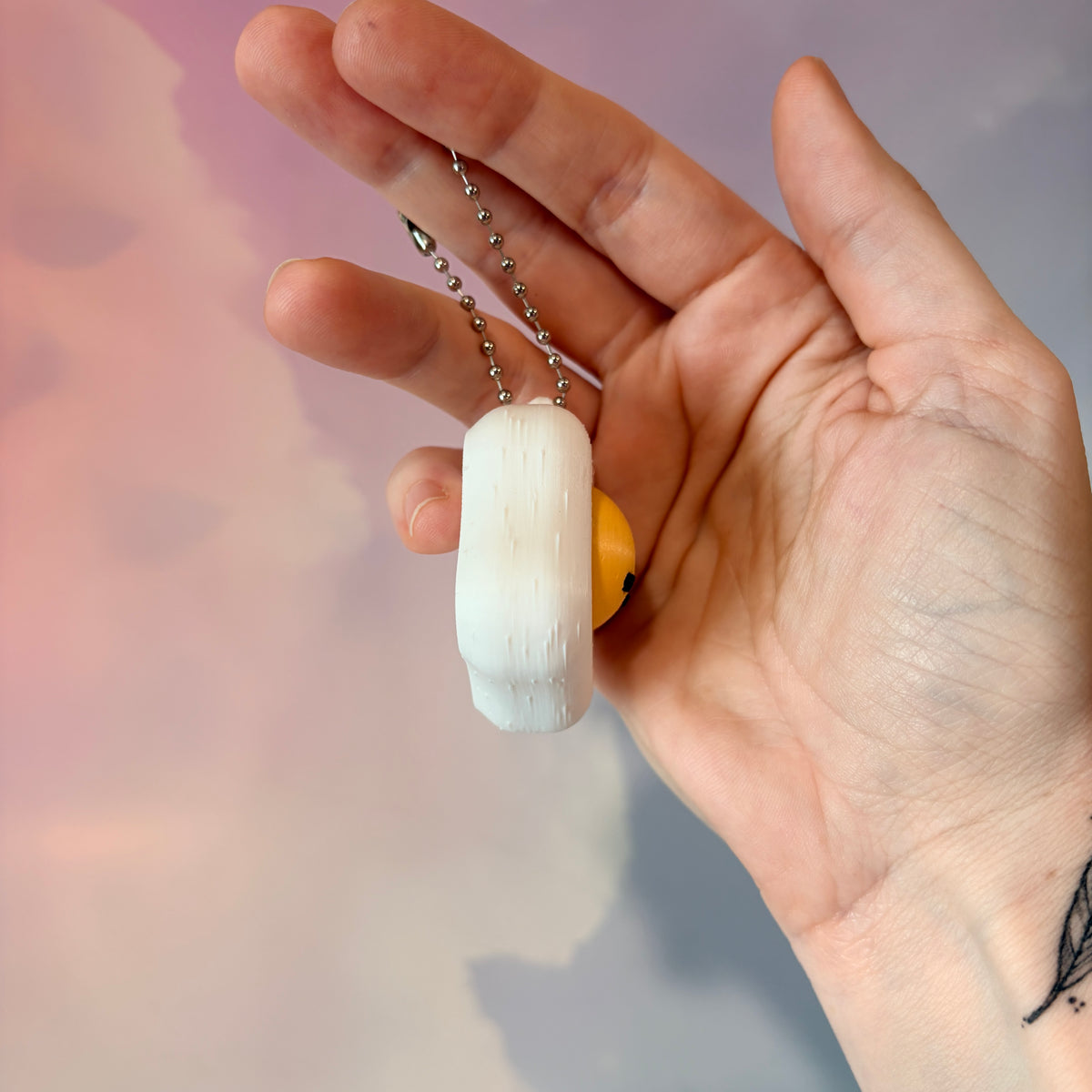 Fried egg shaped fidget clicker toy with a white egg and yellow yolk design, fun food themed desk accessory and satisfying fidget gift.