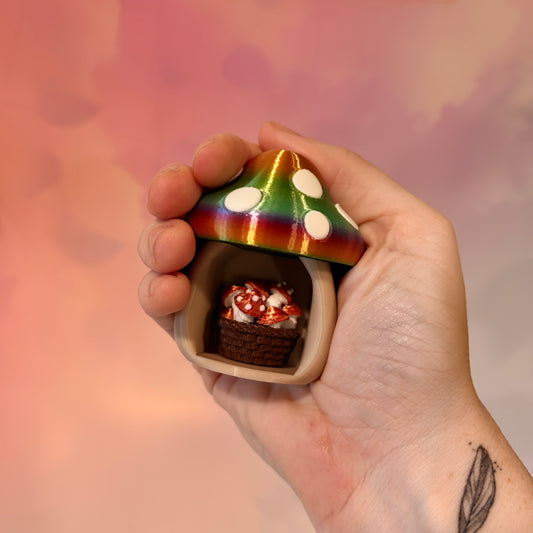 3D printed mushroom basket fidget clicker with a cream base and rainbow-gradient mushroom cap decorated with white spots. Available with a clicky or silent mechanical switch. Cute cottagecore sensory toy for mushroom lovers.
