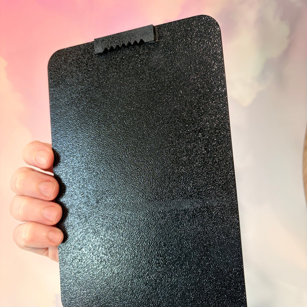 A vertical 3D printed tarot card sign featuring The Moon from the Major Arcana, displayed upright on a small black easel against a soft pink, peach, and lavender background. All 22 Major Arcana tarot card designs are available, allowing customers to choose a card that reflects their interests, spiritual practice, or personal journey.