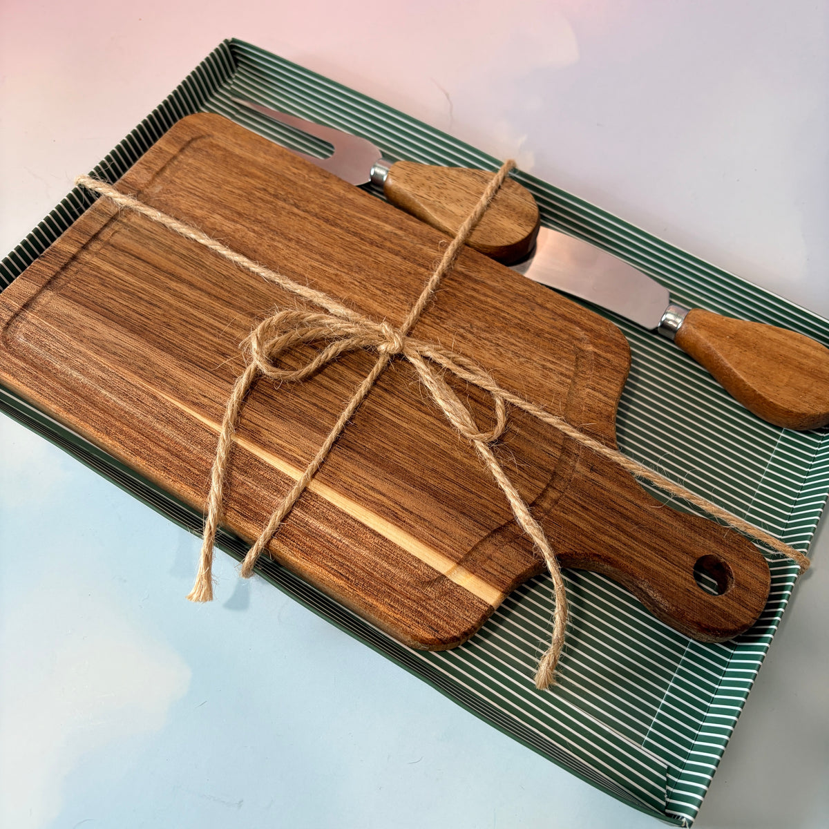 Personalized mini acacia wood charcuterie board with custom laser engraving, approximately 9.5 x 4.7 inches. Includes two serving tools, standard or cursive font options, and gift wrapping for a ready-to-give present.

