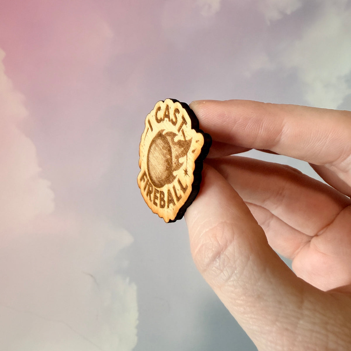 Laser engraved basswood pin reading "I Cast Fireball" for tabletop gamers.