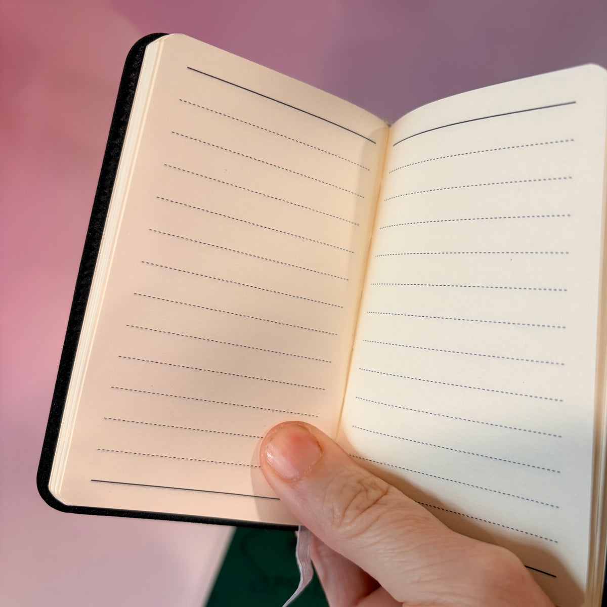 Mini green leather notebook with “Book of Spells” laser engraved on the cover in black lettering. Approximately 4 x 2.5 inches, with 50 lined pages. Available in brown, green, blue, gray, and black.

