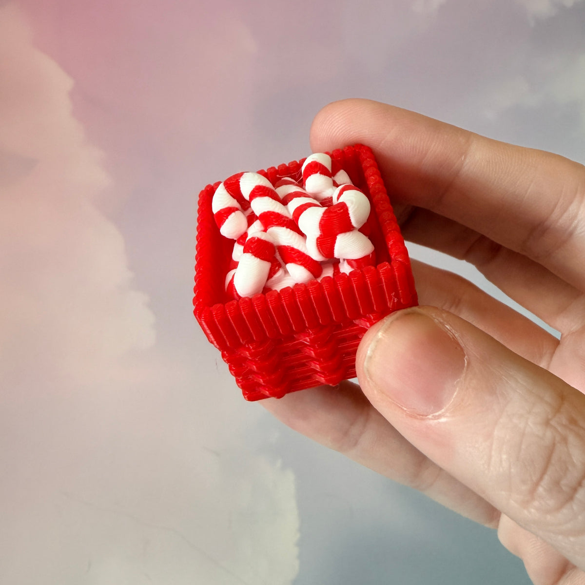 3D printed Christmas fidget clicker featuring a red basket filled with red-and-white candy canes. Available with a clicky or silent mechanism. A festive holiday sensory toy and stocking stuffer for Christmas lovers.