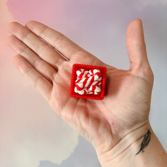 3D printed Christmas fidget clicker featuring a red basket filled with red-and-white candy canes. Available with a clicky or silent mechanism. A festive holiday sensory toy and stocking stuffer for Christmas lovers.