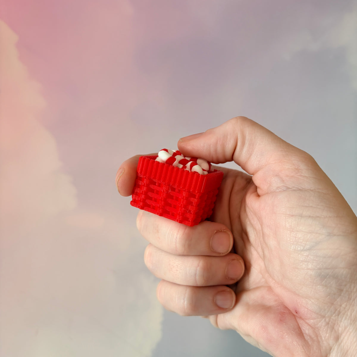 3D printed Christmas fidget clicker featuring a red basket filled with red-and-white candy canes. Available with a clicky or silent mechanism. A festive holiday sensory toy and stocking stuffer for Christmas lovers.