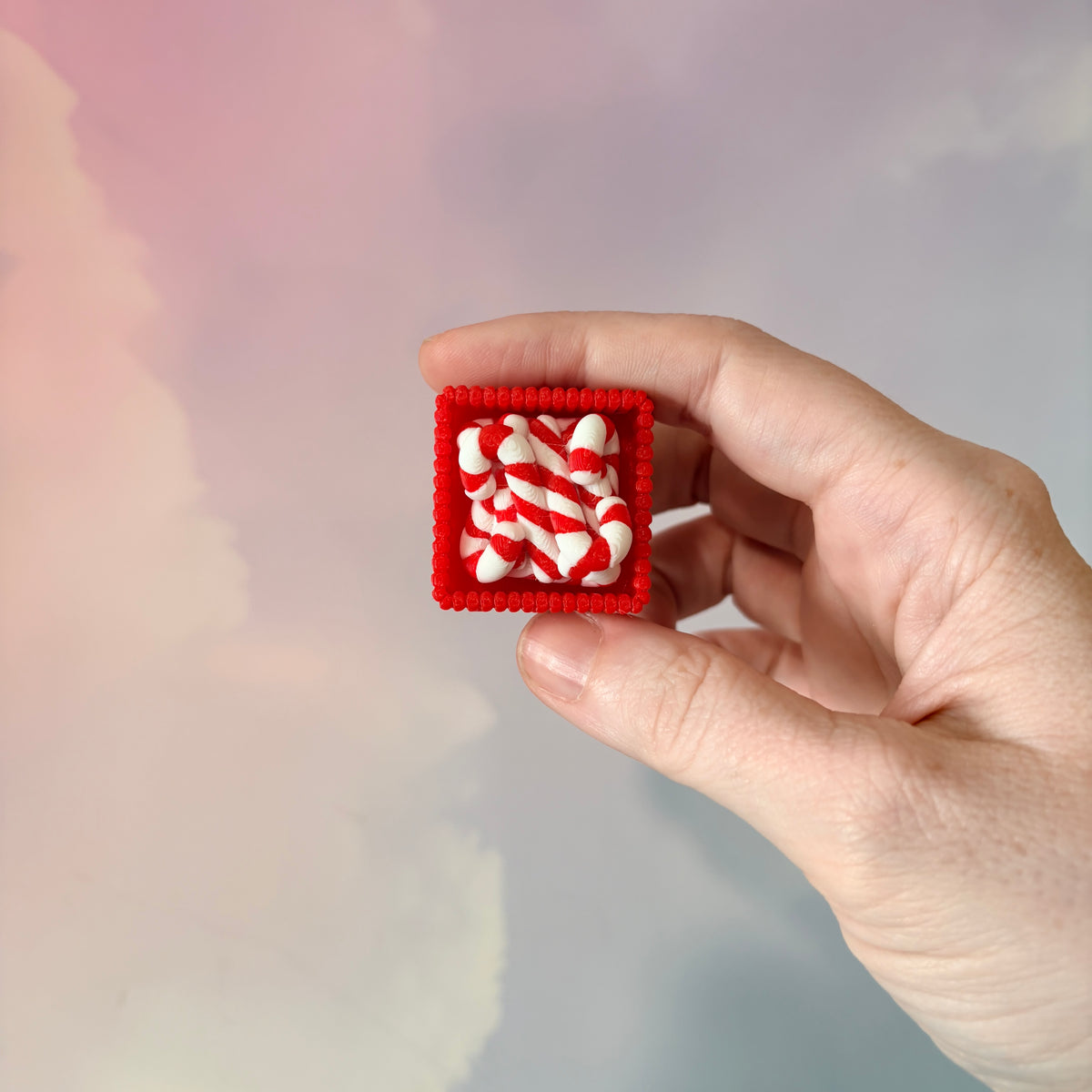 3D printed Christmas fidget clicker featuring a red basket filled with red-and-white candy canes. Available with a clicky or silent mechanism. A festive holiday sensory toy and stocking stuffer for Christmas lovers.