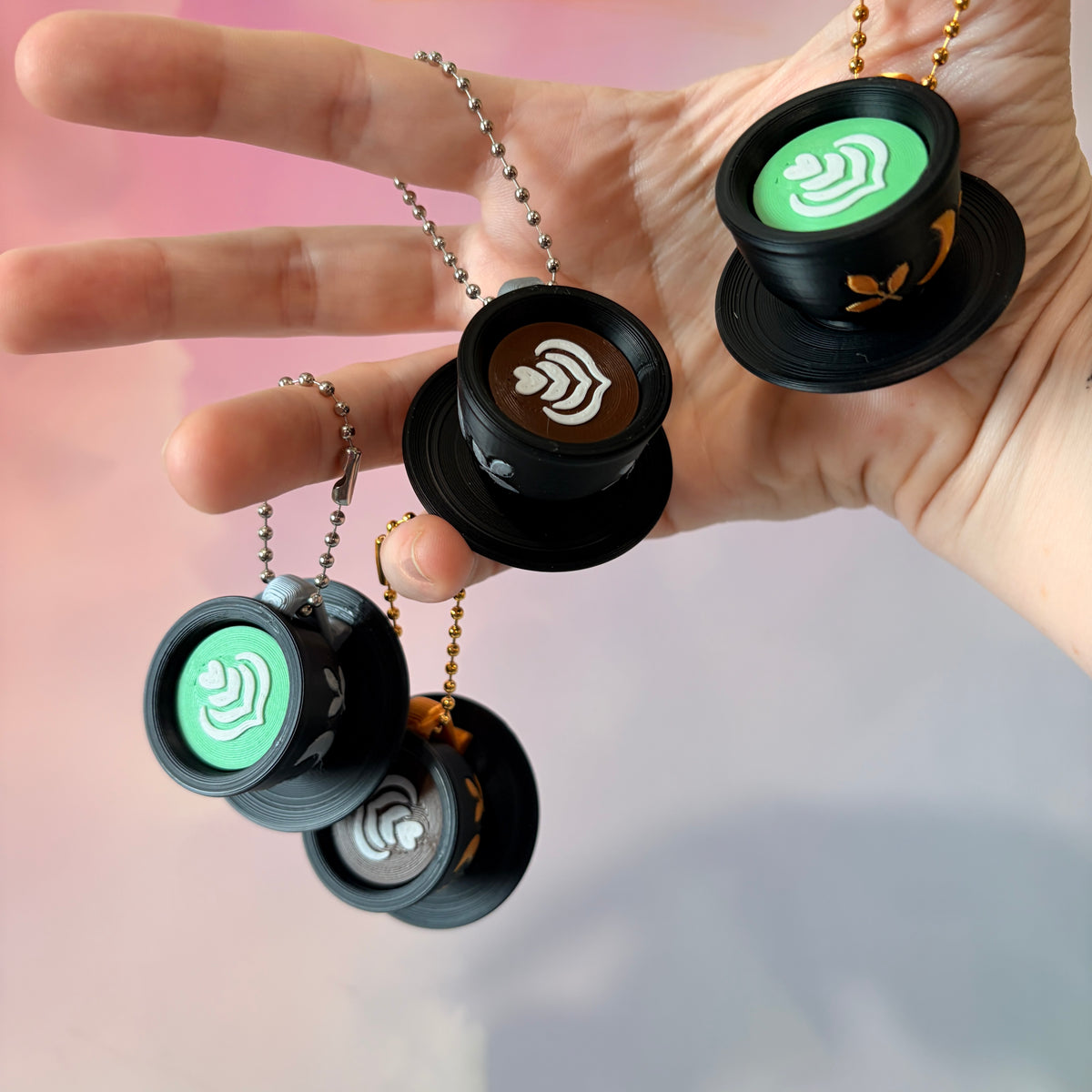 3D printed mystical drink cup fidget clicker keychain with a black floral moon design in gold or silver. Choose matcha or coffee with cute latte art, plus a clicky or silent mechanism.