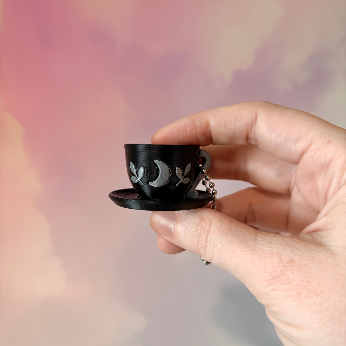 3D printed mystical drink cup fidget clicker keychain with a black floral moon design in gold or silver. Choose matcha or coffee with cute latte art, plus a clicky or silent mechanism.