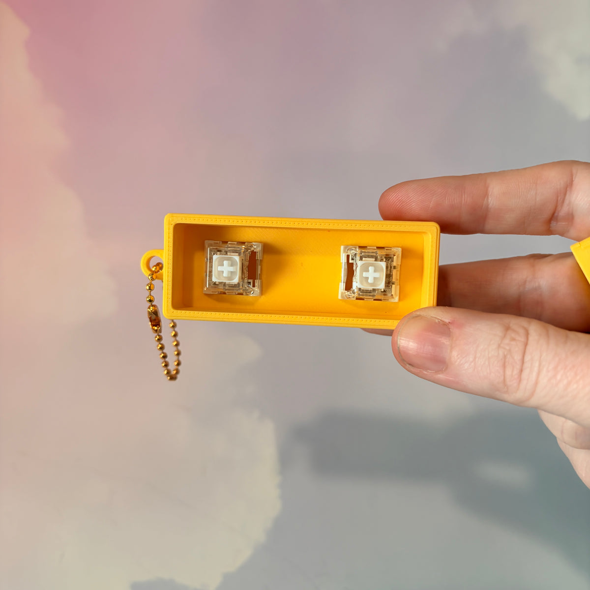 3D printed stick of butter fidget clicker keychain with classic tablespoon marking lines, gold-tone hardware, and two satisfying clicky key switches, perfect for foodies and whimsical accessory lovers.